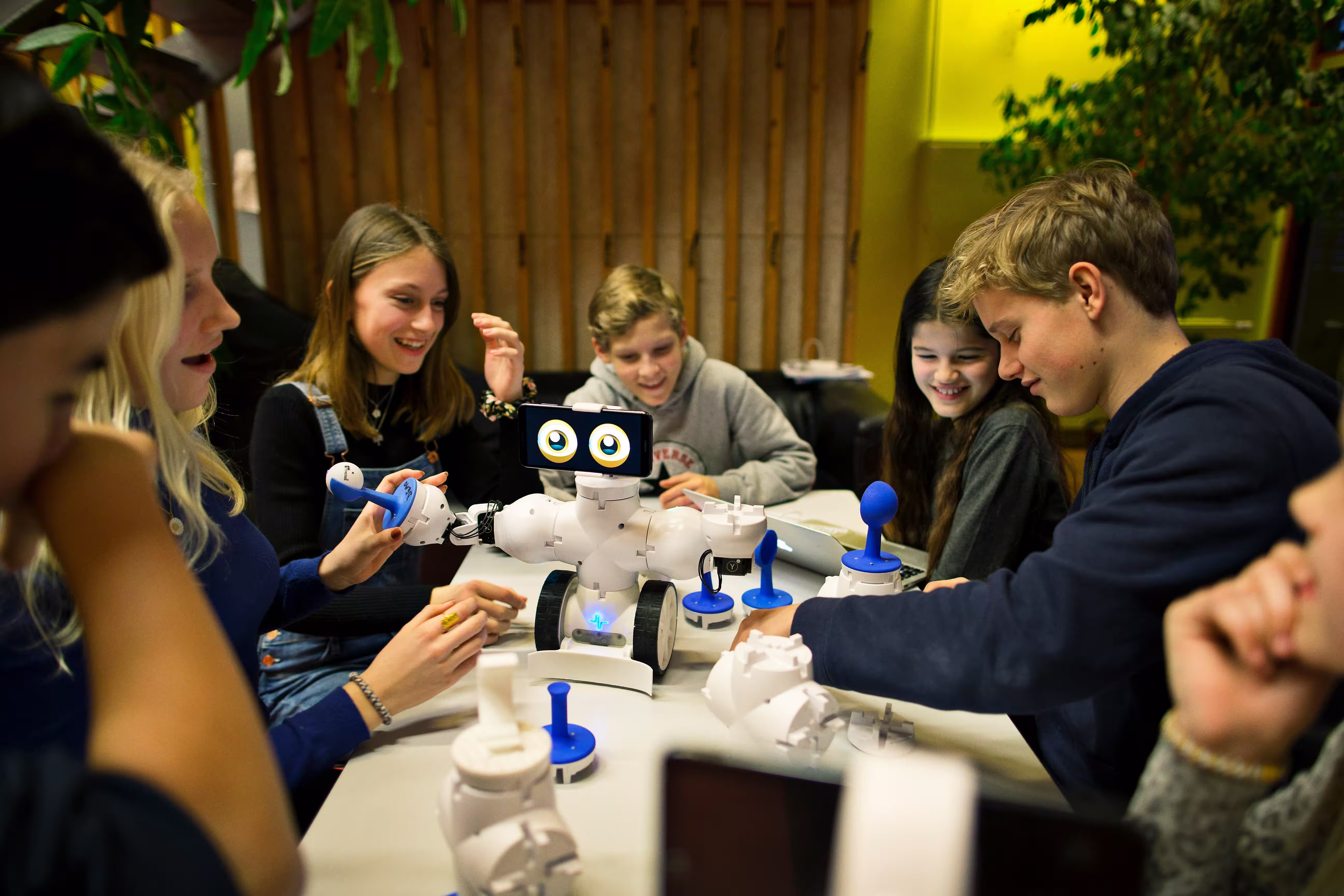 A group of teenagers working together on a robotics project.
